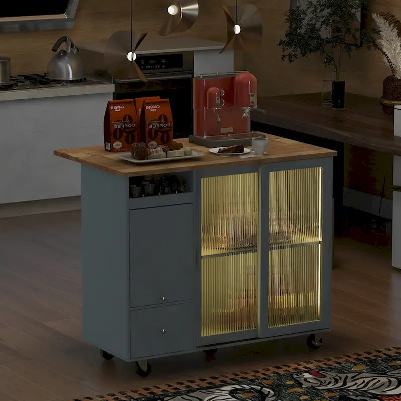 Wózek-wyspa kuchenna z opuszczanym blatem, oświetleniem LED, ryflowanymi szklanymi drzwiami, regulowaną półką i dwiema szufladami